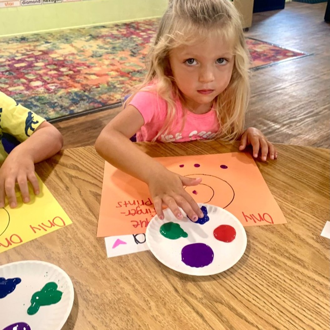 Child painting in a Valdosta preschool program, engaging in a creative hands-on activity.