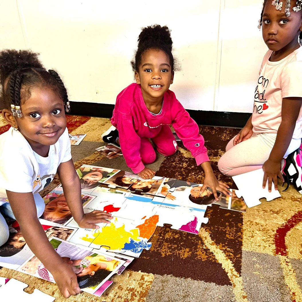 Children playing with a puzzle at Red Trolleys Daycare in Valdosta, GA, engaging in creative and nurturing activities.