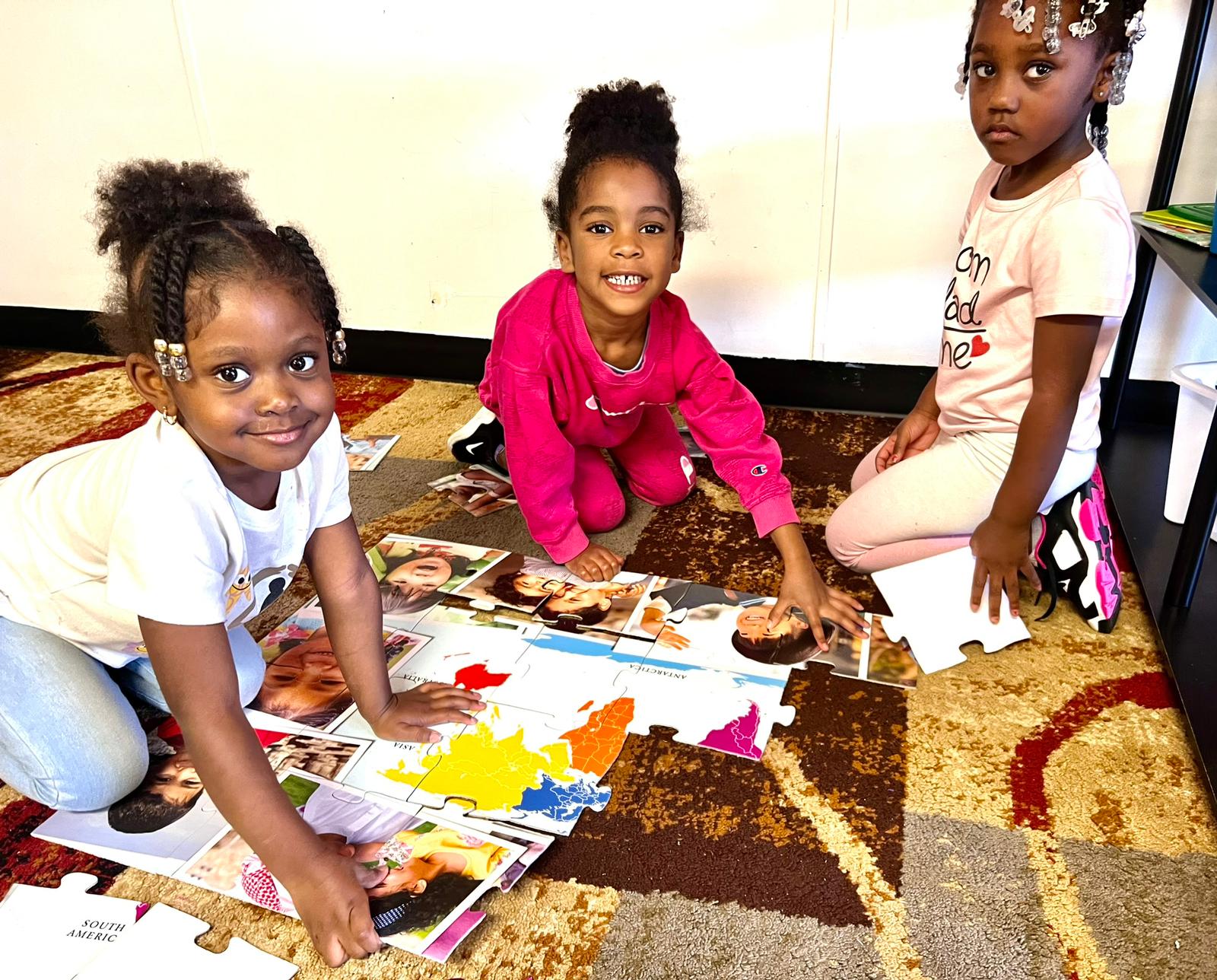 Children playing with a puzzle at Red Trolleys Daycare in Valdosta, GA, engaging in creative and nurturing activities.