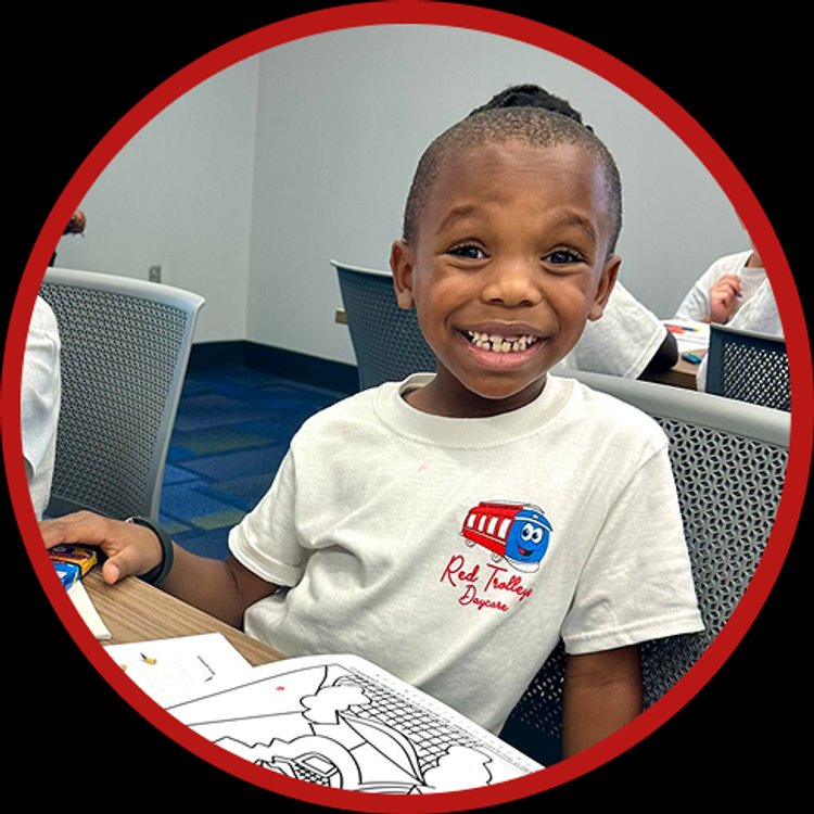 Happy child at Red Trolleys Daycare in Valdosta, GA enjoying preschool activities.