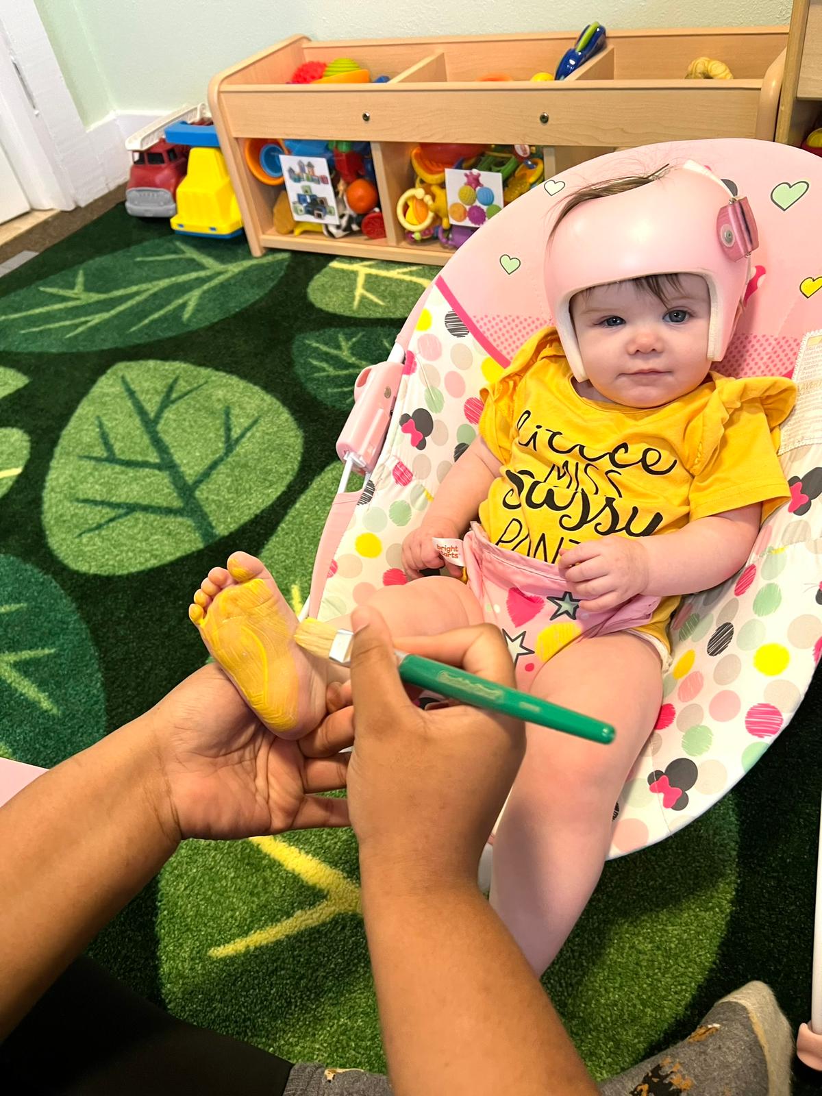 Child at Red Trolleys Daycare in Valdosta, GA enjoying creative foot painting activity.