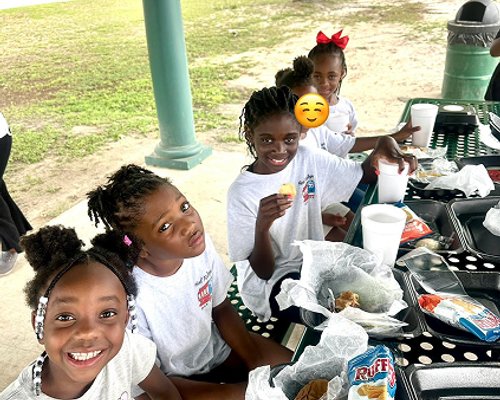 Kids enjoying a meal at Red Trolleys Daycare in Valdosta, GA.