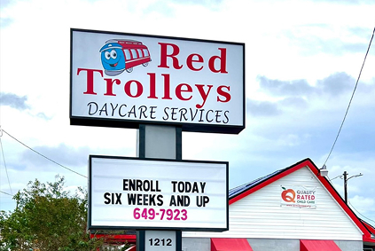 Sign outside Red Trolleys Daycare in Valdosta, GA, offering child care and preschool programs.