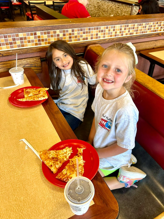 Children enjoying pizza at Red Trolleys Daycare in Valdosta, GA. Nurturing environment for child care and preschool.