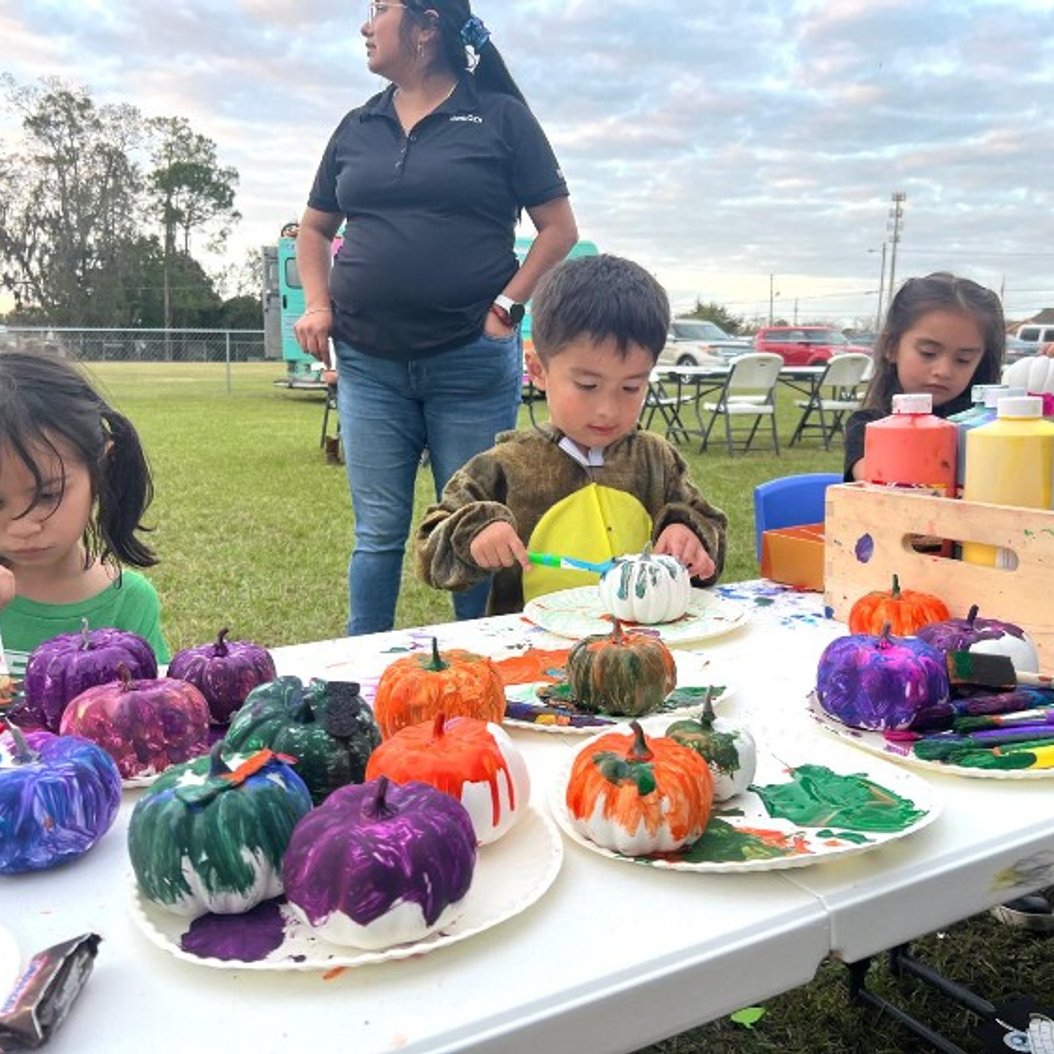 Toddlers painting pumpkins outdoors at Active Xplorers daycare in Valdosta, GA.