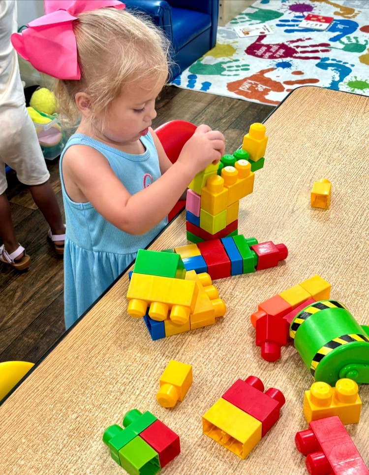 Toddler playing with colorful blocks at Active Xplorers daycare in Valdosta, GA, fostering learning and growth.