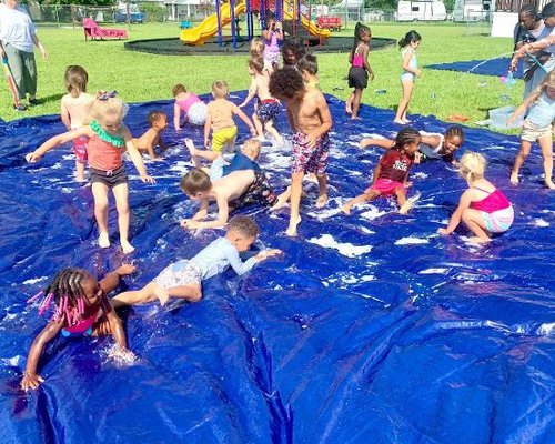 Children enjoying outdoor water play at Red Trolleys Daycare in Valdosta, GA.
