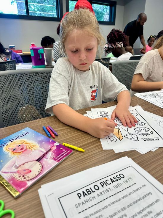 Child coloring at Red Trolleys Daycare in Valdosta, GA, promoting nurturing preschool and school-age programs.