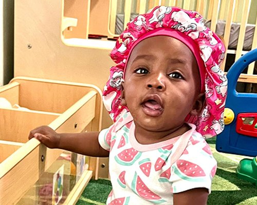 Infant enjoying safe and nurturing environment at Red Trolleys Daycare in Valdosta, GA.