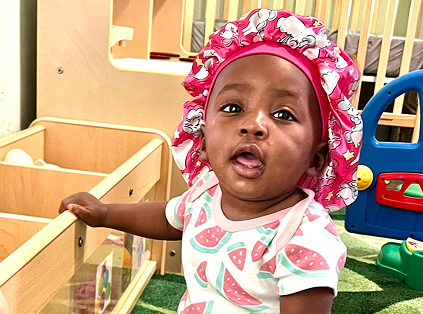 Infant enjoying safe and nurturing environment at Red Trolleys Daycare in Valdosta, GA.