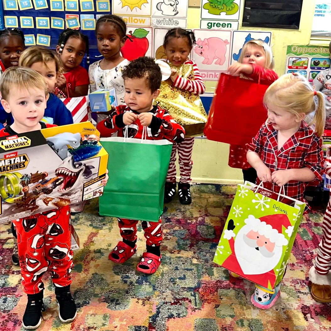 Children at Red Trolleys Daycare in Valdosta, GA with gifts, showcasing affordable child care through CAPS assistance.