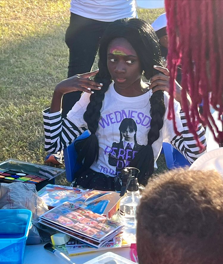 Child having fun at the face painting station during a Red Trolleys Daycare event in Valdosta, GA.