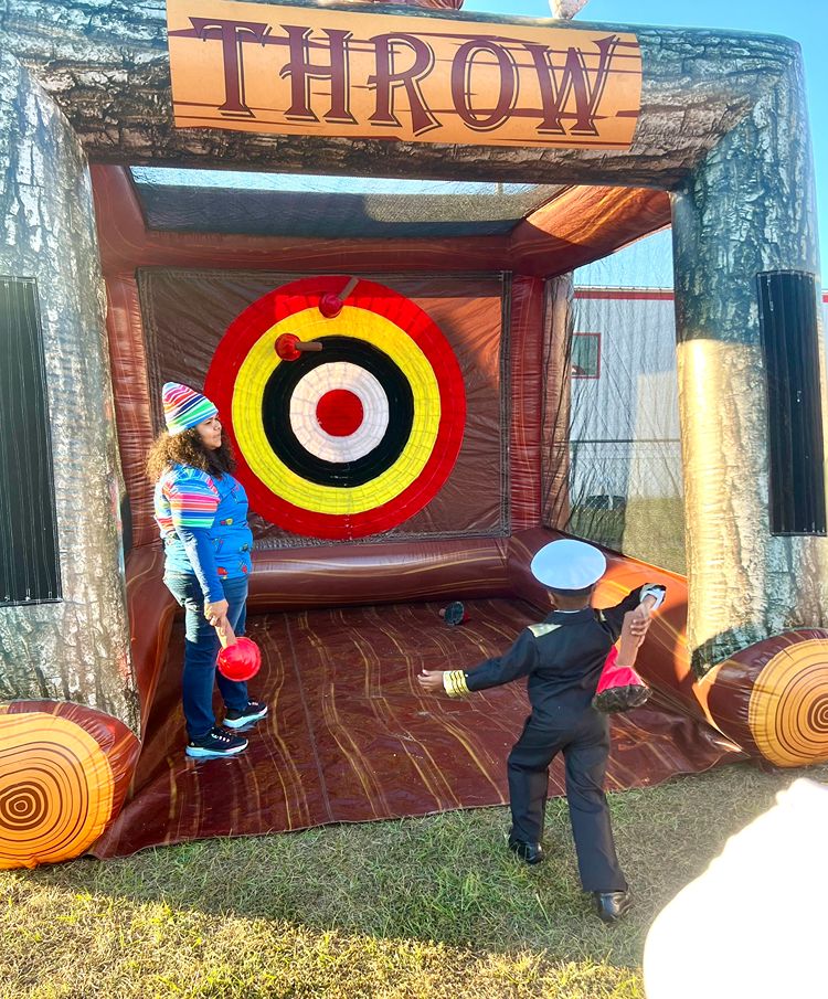 Child playing an inflatable target-throw game at a Red Trolleys Daycare event in Valdosta, GA.