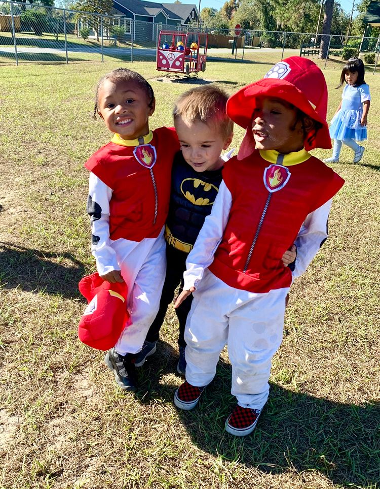 Children dressed in costumes playing outside during a Red Trolleys Daycare celebration in Valdosta, GA.