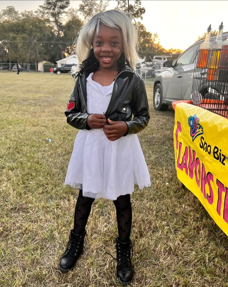 Child showing off a costume at the Red Trolleys Daycare fall festival in Valdosta, GA.