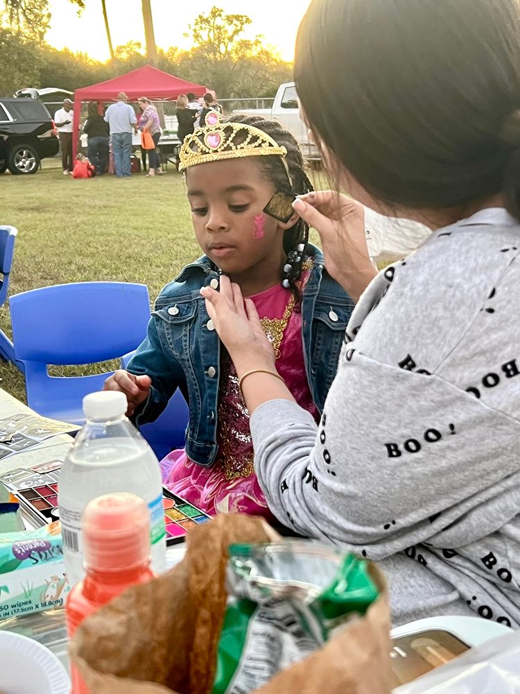 Child getting festive face paint at a Red Trolleys Daycare event in Valdosta, GA.